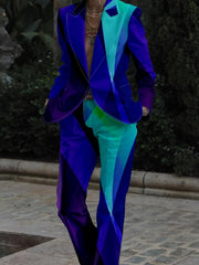 A person wears a slim-fit suit featuring a vibrant, geometric digital print in blue and teal.