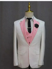 A white slim-fit blazer with a pink shawl lapel and matching vest worn with a black tie.