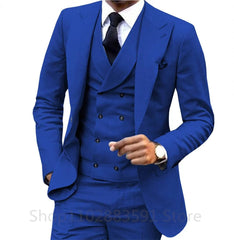 A man wears a slim-fit royal blue three-piece suit with a double-breasted vest and black tie.