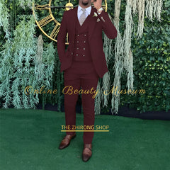 A man wears a burgundy three-piece suit consisting of a single-breasted jacket, double-breasted vest, and matching trousers.