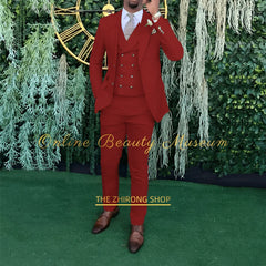 A man wears a red three-piece suit consisting of a single-breasted jacket, double-breasted vest, and trousers.