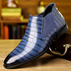 A blue faux leather ankle boot with a plaid pattern, elastic side panel, and black rubber sole.