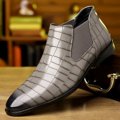 A grey faux leather ankle boot with a plaid pattern, elastic side panel, and black rubber sole.