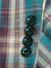 A close-up view of a plaid suit sleeve featuring four dark buttons and matching buttonholes.