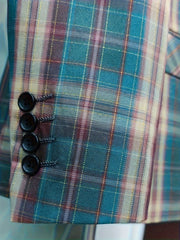 A close-up of a teal and burgundy plaid suit sleeve featuring four black buttons at the cuff.