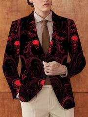 A man wears a black blazer featuring a red skull and scrollwork pattern over a striped shirt.