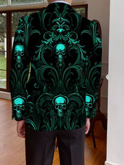 A man wears a black blazer featuring an all-over teal skull and ornate scrollwork print.