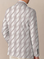 A man wears a regular fit, casual suit jacket featuring a light-colored diagonal geometric print.