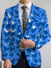 A man wears a blue blazer featuring a repeating heart pattern over a white shirt and tie.