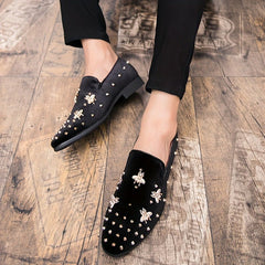 Black corduroy slip-on dress shoes featuring gold bee embellishments and metal studs.
