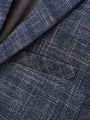 A close-up of a navy blue blazer featuring a textured plaid pattern and a welt chest pocket.
