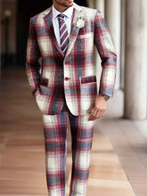 A man wears a classic fit plaid suit in shades of red, white, and grey with a matching tie.