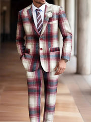 A man wears a classic fit plaid suit in shades of red, white, and grey with a matching tie.