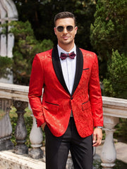 A man wears a red paisley floral tuxedo jacket with a black shawl lapel and a matching bow tie.