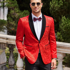 A man wears a red floral paisley tuxedo jacket with a black shawl lapel and a matching bow tie.