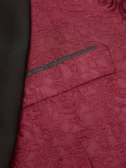 A close-up of a burgundy paisley patterned tuxedo jacket featuring a black pocket trim.