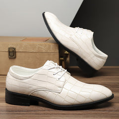 A pair of white crocodile-pattern lace-up dress shoes with black soles.
