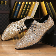 A pair of men's gold glitter lace-up dress shoes with a pointed toe and black soles.