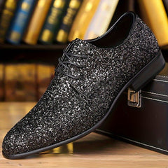 A black glittery men's lace-up dress shoe with a pointed toe and low-top silhouette.