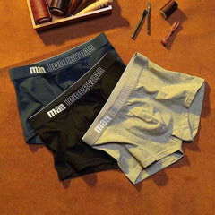 Three pairs of men's mid-waist cotton boxer briefs in blue, black, and grey.