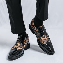 Men's leopard print pointed-toe oxford dress shoes with black patent leather accents and laces.