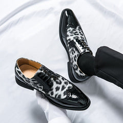 Men's leopard print lace-up oxford dress shoes with a black patent leather pointed toe and sole.