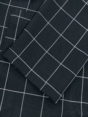 Close-up of a black blazer featuring a white grid plaid pattern and a notched lapel.