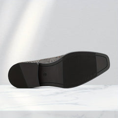 A bottom view of a men's formal loafer with a textured black sole and a size nine marking.