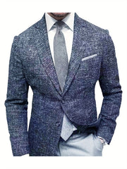 A man wears a textured blue single-breasted blazer with a notched lapel over a white shirt and grey tie.