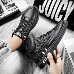 A pair of black low-top lace-up sneakers with a textured crocodile-patterned upper.