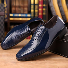 A pair of glossy navy blue lace-up dress shoes with a crocodile texture and pointed toe.