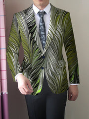 A man wears a slim-fit blazer featuring a vibrant green and white feather-like print.