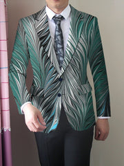 A man wears a slim-fit blazer featuring a vibrant green and white feather-like print.