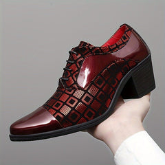 A hand holds a burgundy and black patterned lace-up dress shoe with a block heel.