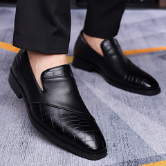 A pair of black slip-on business shoes featuring a pointed toe and a textured crocodile-skin pattern.