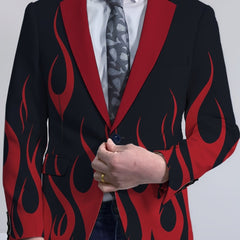 A man wears a black blazer featuring a red flame print, a lapel collar, and a single button closure.