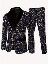 A men's skinny fit suit featuring a black blazer with a velvet lapel and matching pants in a multicolored confetti print.