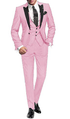 A man wears a light pink three-piece suit with a black peak lapel, vest, and polka dot tie.