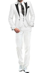 A man wears a white three-piece suit featuring a black peak lapel, a polka dot tie, and white shoes.