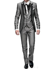 A man wears a grey three-piece suit featuring a peak lapel jacket, vest, and matching trousers.