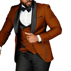 A man wears a slim-fit, three-piece rust-colored tuxedo with a black shawl lapel and vest.