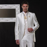 A man wears a white satin three-piece wedding suit featuring a single-breasted jacket and vest.