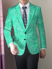A man wears a bright green blazer featuring a white starfish and floral print over a white shirt.