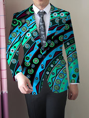 A man wears a skinny-fit blazer featuring a vibrant, multicolored geometric and floral print.