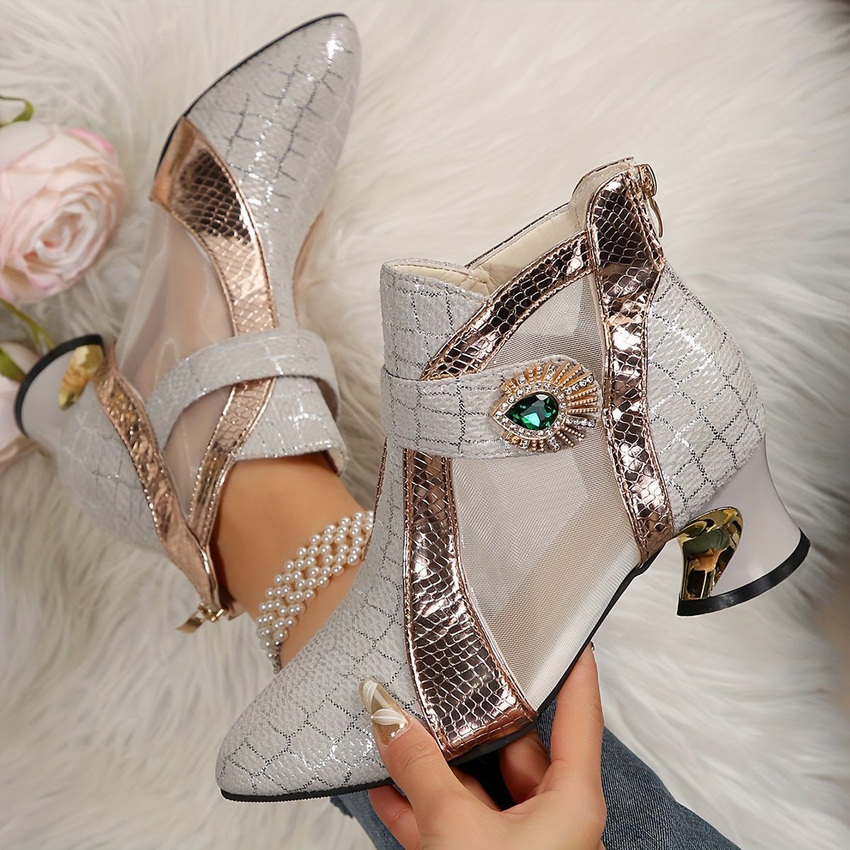 Pointed-toe mesh ankle boots featuring metallic snakeskin accents and a decorative green gem.