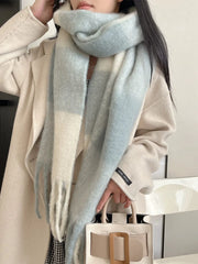 A soft, oversized colorblock plaid scarf in shades of cream and light blue.