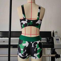 A two-piece camouflage print swimsuit featuring a crop top with an open back and matching shorts.