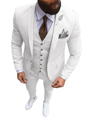 A man wears a white three-piece slim-fit suit with a brown tie and white sneakers.