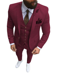 A man wears a slim-fit, three-piece pink suit with a notch lapel, white shirt, and white sneakers.