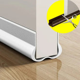 A white flexible PVC door bottom sealing strip installed on a door with a scissor cutting inset.